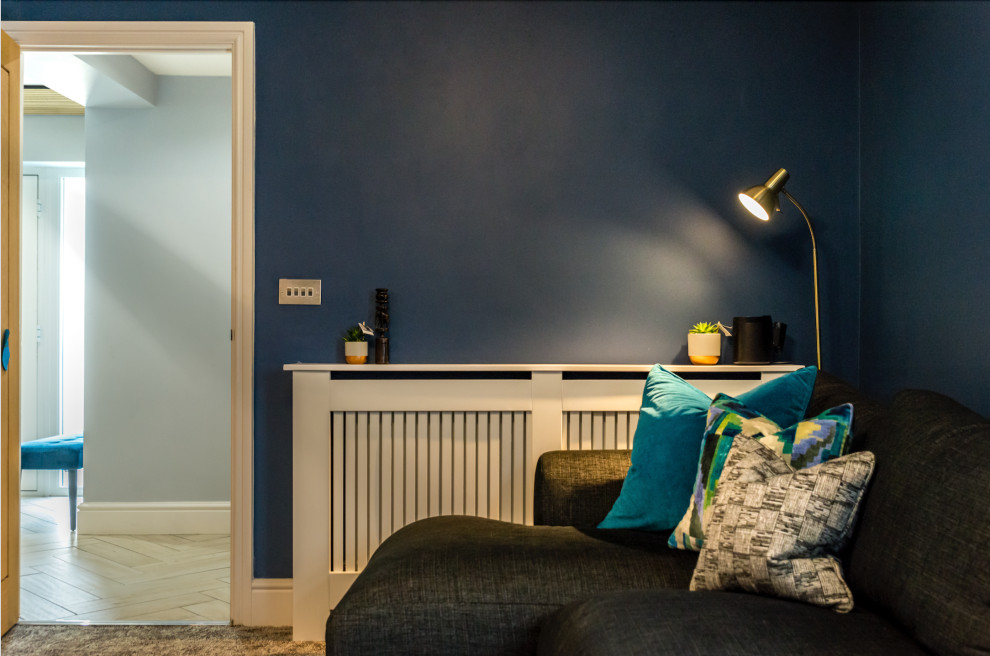 Mittelgroßes, Abgetrenntes Modernes Heimkino mit blauer Wandfarbe, Teppichboden, TV-Wand und beigem Boden in Sonstige