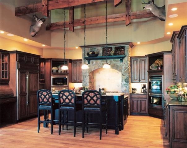 Example of a large mountain style u-shaped light wood floor kitchen design in Cincinnati with raised-panel cabinets, dark wood cabinets, granite countertops, stainless steel appliances and an island