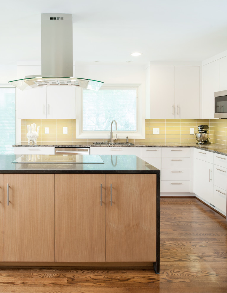 Inspiration for a mid-sized modern l-shaped separate kitchen in Kansas City with flat-panel cabinets, light wood cabinets, granite benchtops, yellow splashback, glass tile splashback, stainless steel appliances, medium hardwood floors, with island and a double-bowl sink.