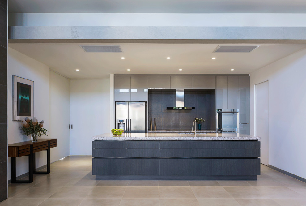 Inspiration for a large modern galley open plan kitchen in Melbourne with flat-panel cabinets, marble benchtops, grey splashback, porcelain splashback, stainless steel appliances and with island.