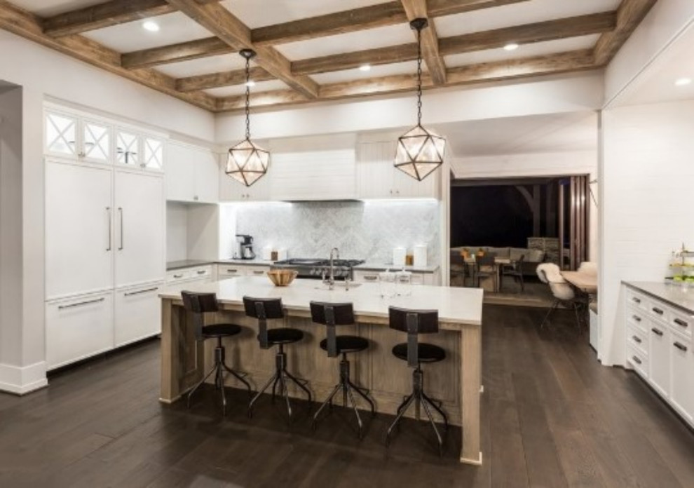 This is an example of a traditional kitchen/diner in San Francisco with a belfast sink, shaker cabinets, white cabinets, engineered stone countertops, white appliances, dark hardwood flooring, an island and exposed beams.