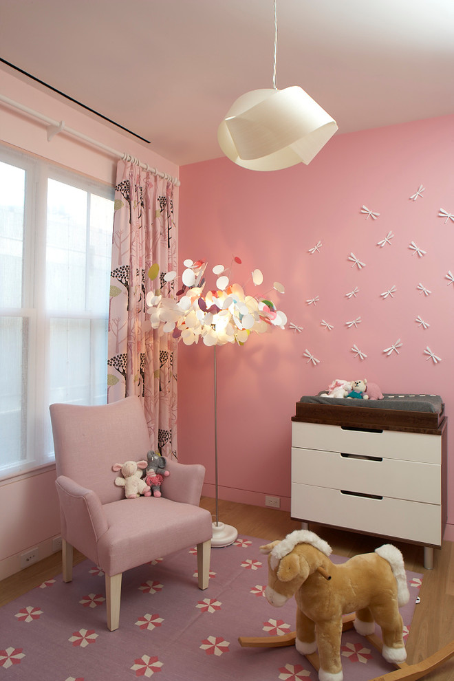 This is an example of a transitional kids' room in New York with pink walls.