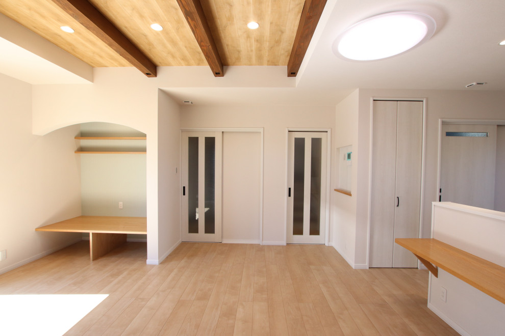 Offenes Modernes Wohnzimmer mit Sperrholzboden, freigelegten Dachbalken und Tapetenwänden in Sonstige