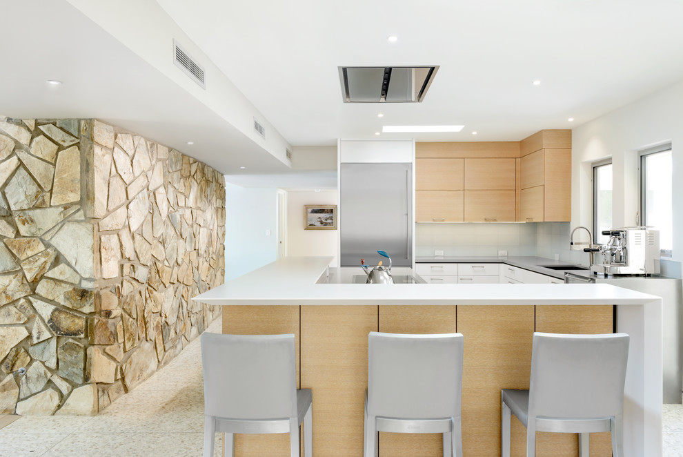Design ideas for a small midcentury l-shaped open plan kitchen in Phoenix with an undermount sink, flat-panel cabinets, light wood cabinets, quartz benchtops, grey splashback, glass tile splashback, stainless steel appliances and with island.