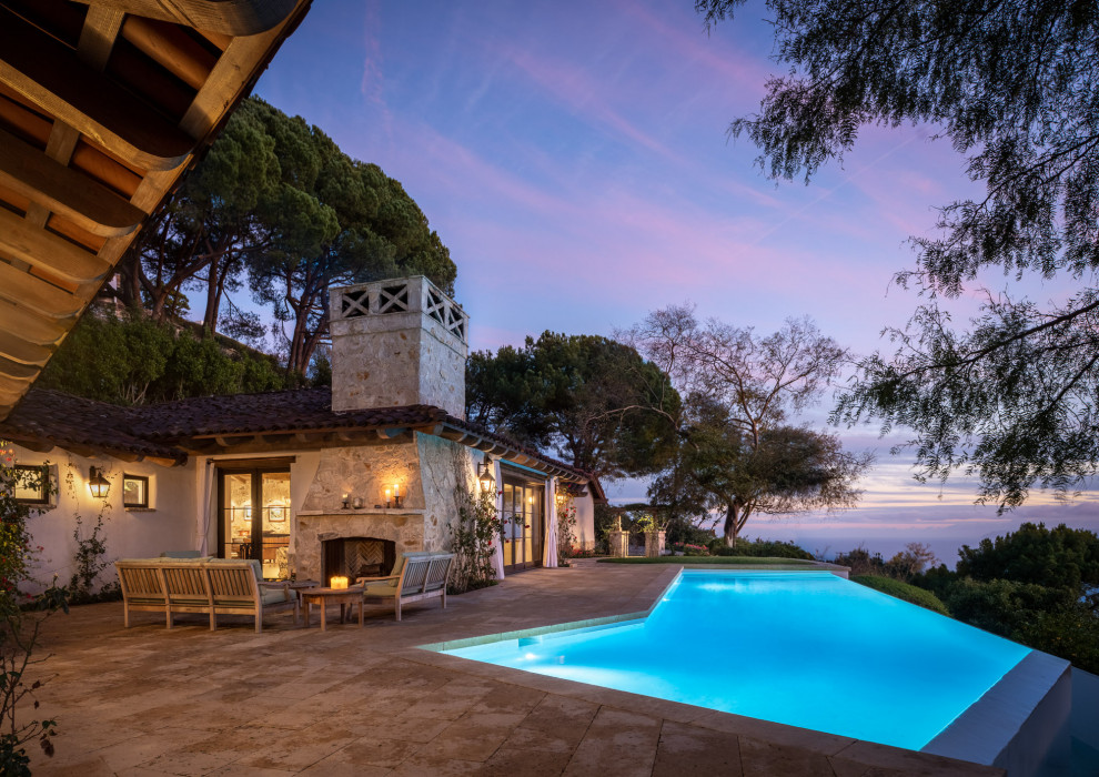 Diseño de piscina infinita rústica de tamaño medio a medida en patio delantero con adoquines de piedra natural