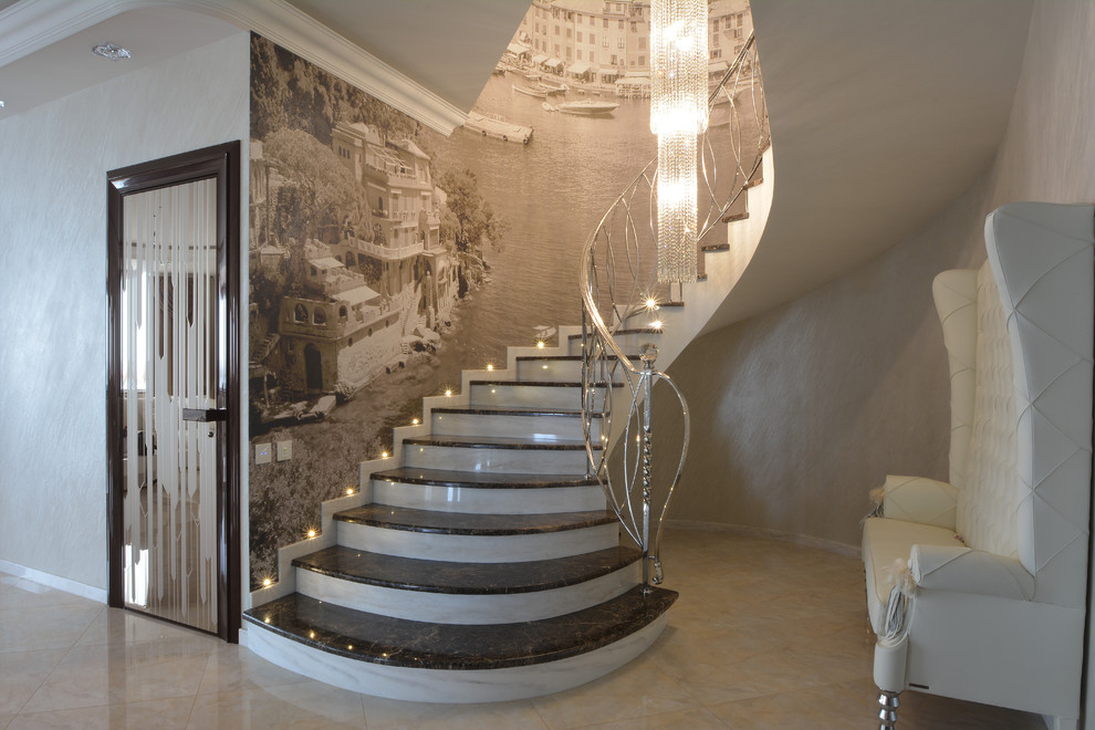 This is an example of a large transitional marble spiral staircase in Moscow with marble risers and metal railing.