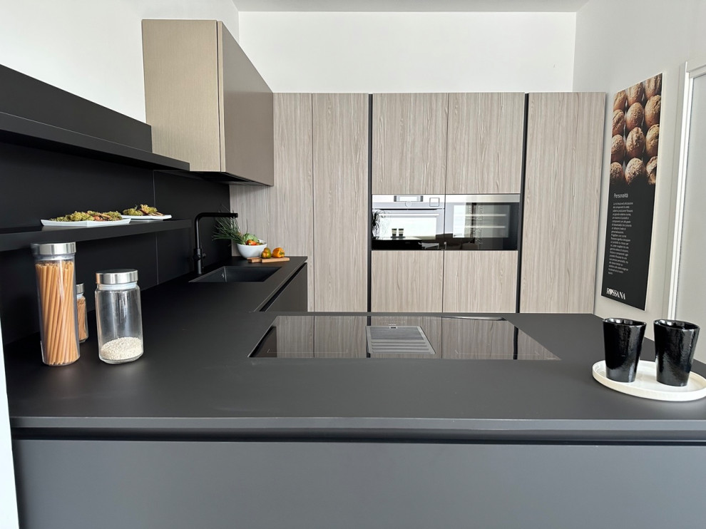 Idee per una grande cucina minimalista con lavello sottopiano, ante lisce, ante nere, top in laminato, paraspruzzi nero, elettrodomestici in acciaio inossidabile, pavimento in cemento, pavimento grigio e top nero