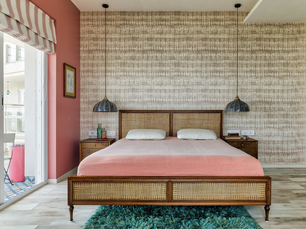 Design ideas for a mid-sized tropical master bedroom in Mumbai with pink walls and brown floor.