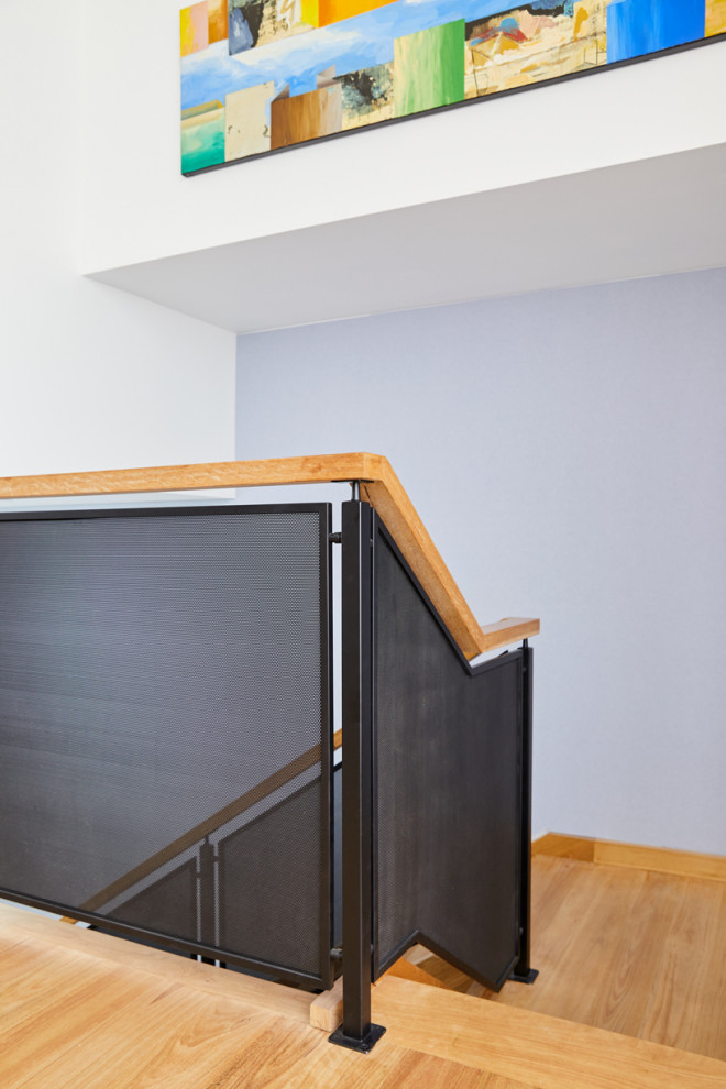 На фото: угловая лестница среднего размера в современном стиле с деревянными ступенями и деревянными перилами без подступенок с