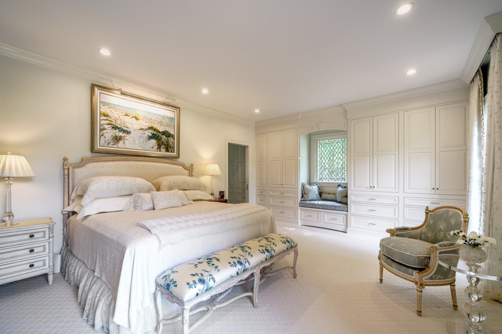 This is an example of a traditional master bedroom in Other with white walls, carpet and beige floor.