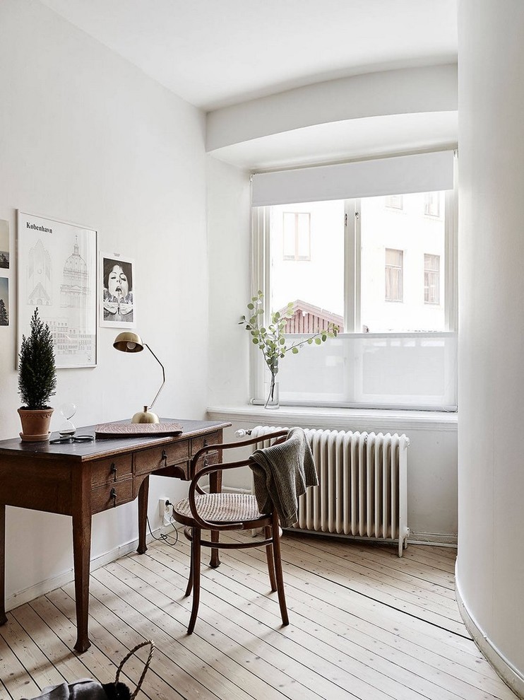 Example of a danish freestanding desk light wood floor study room design in London with white walls and no fireplace
