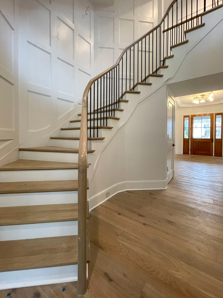 Design ideas for a large traditional wood floating mixed railing staircase in DC Metro with painted wood risers and wainscoting.