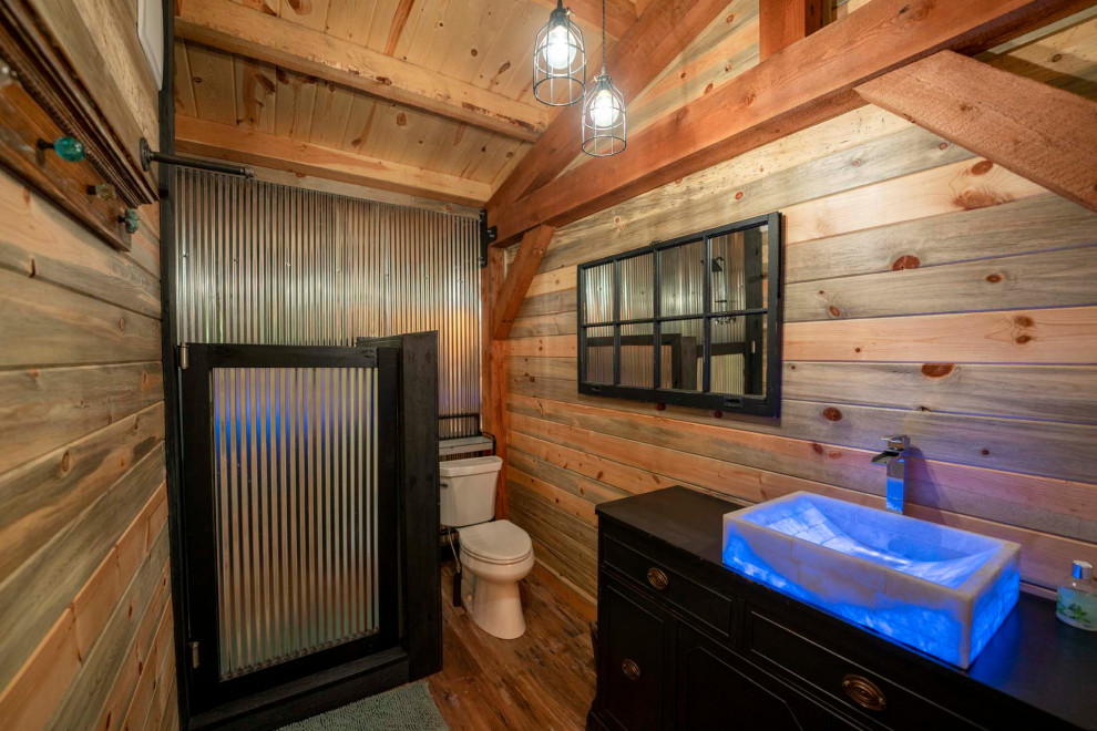 Idée de décoration pour une petite salle de bain principale chalet avec WC à poser, un sol en bois brun, un sol marron, meuble simple vasque, meuble-lavabo sur pied, un plafond voûté et du lambris de bois.