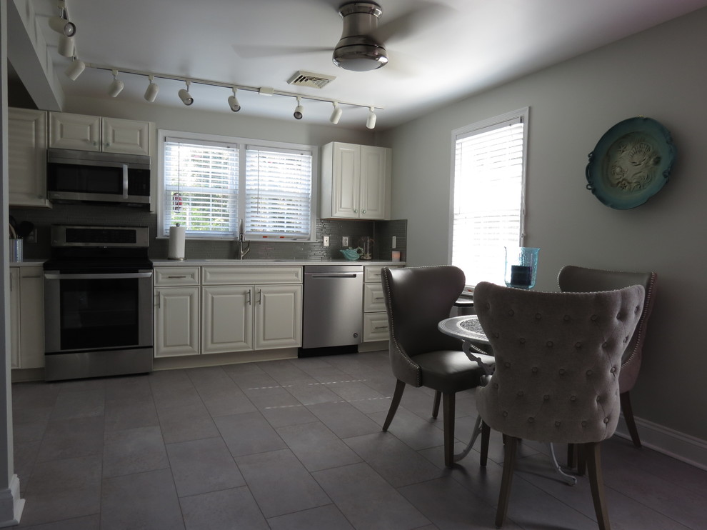 Mid-sized transitional l-shaped purple floor eat-in kitchen photo with an undermount sink, raised-panel cabinets, white cabinets, quartz countertops, gray backsplash, glass tile backsplash, stainless steel appliances, no island and white countertops