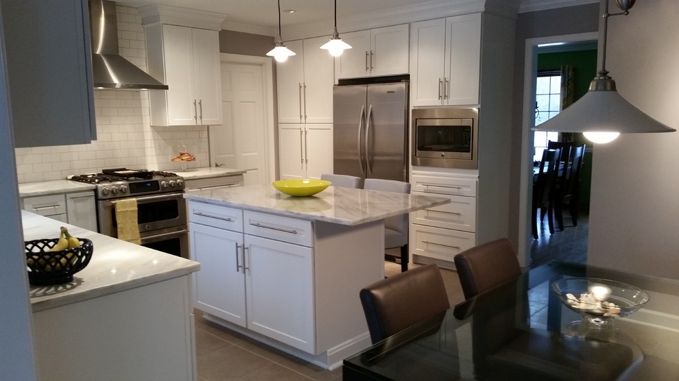 Eat-in kitchen - mid-sized transitional u-shaped ceramic tile and gray floor eat-in kitchen idea in Chicago with an undermount sink, recessed-panel cabinets, white cabinets, marble countertops, white backsplash, subway tile backsplash, stainless steel appliances and an island