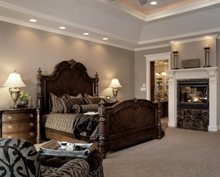 Photo of a large traditional master bedroom in Kansas City with beige walls, carpet, a two-sided fireplace and a tile fireplace surround.