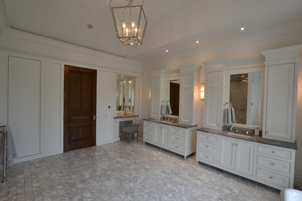 Photo of a traditional master bathroom in Toronto with shaker cabinets, white cabinets, a freestanding tub, an open shower, a two-piece toilet, white walls, marble floors, an undermount sink, marble benchtops, grey floor and an open shower.