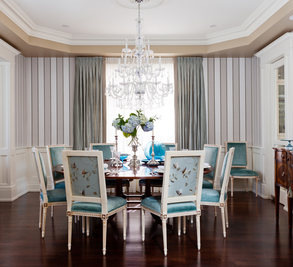 This is an example of a traditional dining room in Toronto with multi-coloured walls and dark hardwood floors.