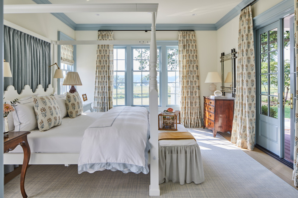 Design ideas for a large master bedroom in Louisville with white walls, light hardwood flooring and brown floors.