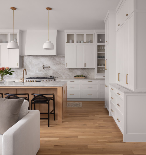 White shaker RTA cabinets in a modern Canadian kitchen with wood island and marble countertop, showing affordable yet premium design