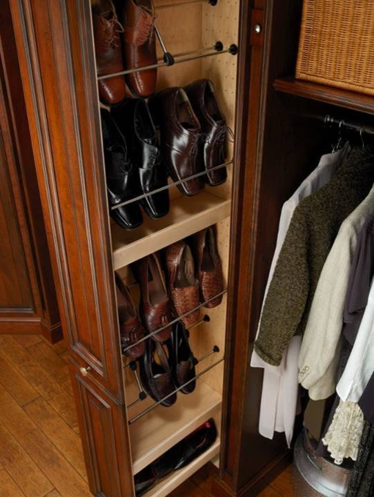 Walk-in closet - large traditional gender-neutral light wood floor and yellow floor walk-in closet idea in Houston with raised-panel cabinets and dark wood cabinets
