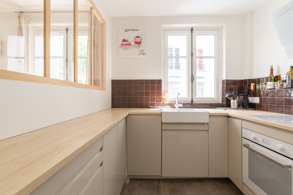 Inspiration for a mid-sized traditional u-shaped open plan kitchen in Paris with a drop-in sink, beige cabinets, red splashback, ceramic splashback, white appliances, no island, beige floor and beige benchtop.