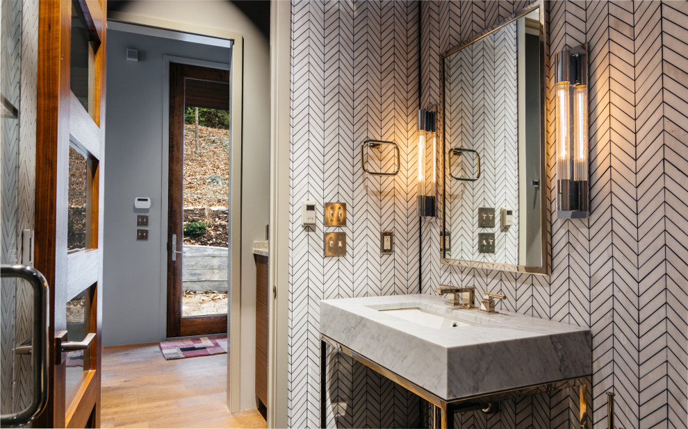 Photo of a mid-sized modern 3/4 bathroom in Nashville with open cabinets, white cabinets, an alcove shower, a wall-mount toilet, white tile, marble, white walls, marble floors, an integrated sink, marble benchtops, black floor, a hinged shower door, white benchtops, a shower seat, a single vanity and a freestanding vanity.