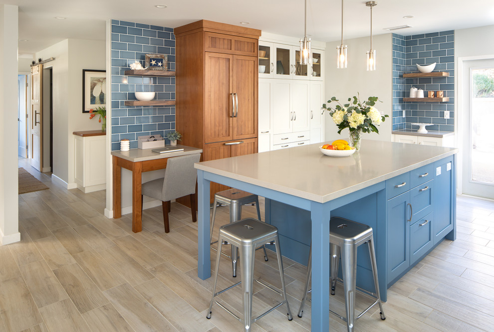 Design ideas for a large transitional u-shaped eat-in kitchen in San Diego with an undermount sink, shaker cabinets, white cabinets, quartz benchtops, blue splashback, ceramic splashback, panelled appliances, porcelain floors, with island, brown floor and grey benchtop.
