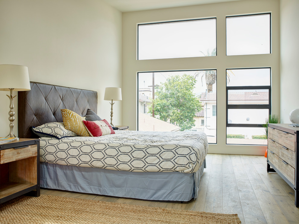 Inspiration for a large contemporary master bedroom in Los Angeles with white walls and plywood floors.