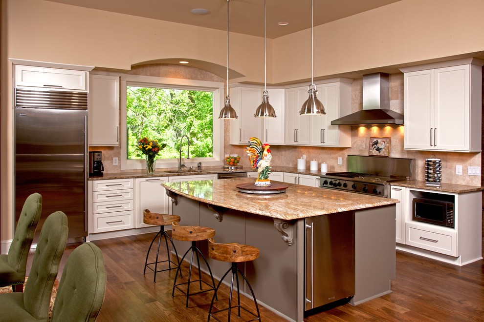 Inspiration for a large rustic l-shaped medium tone wood floor eat-in kitchen remodel in Minneapolis with an integrated sink, flat-panel cabinets, white cabinets, granite countertops, beige backsplash, ceramic backsplash, stainless steel appliances and an island