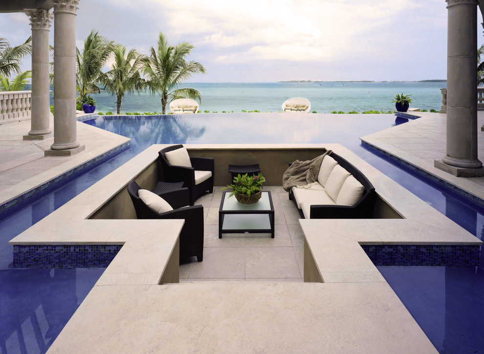 Design ideas for an expansive traditional backyard custom-shaped infinity pool in Other with tile.