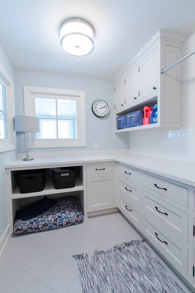 This is an example of a mid-sized transitional galley dedicated laundry room in Minneapolis with a drop-in sink, flat-panel cabinets, white cabinets, blue walls and ceramic floors.