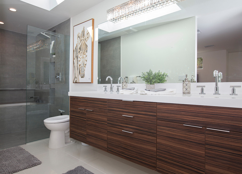 Inspiration for a large midcentury master bathroom in Los Angeles with flat-panel cabinets, brown cabinets, a corner shower, a two-piece toilet, gray tile, porcelain tile, white walls, porcelain floors, an undermount sink, quartzite benchtops, grey floor and a hinged shower door.