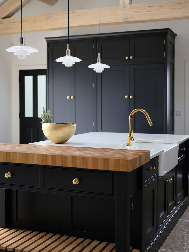 Inspiration for a transitional kitchen in Cheshire with a farmhouse sink, black cabinets, quartzite benchtops, with island and white benchtop.