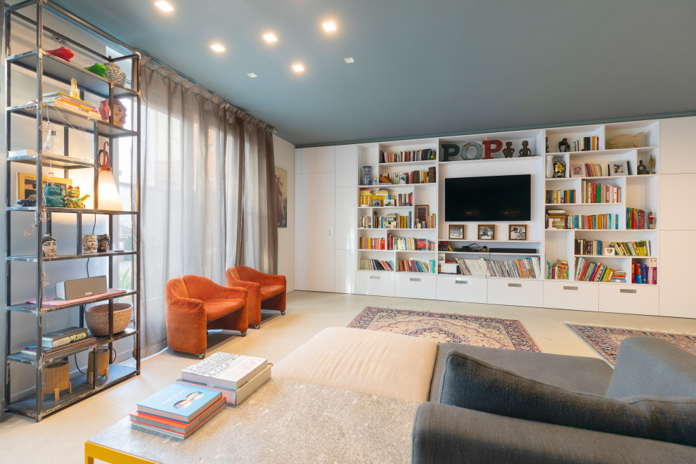 Large contemporary loft-style living room in Milan with a library, blue walls, concrete floors, a wall-mounted tv and grey floor.