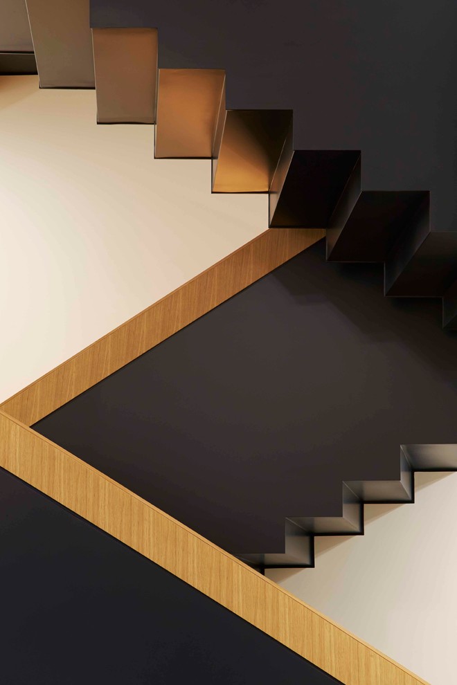 Inspiration for a large contemporary wood curved staircase in London with wood risers.