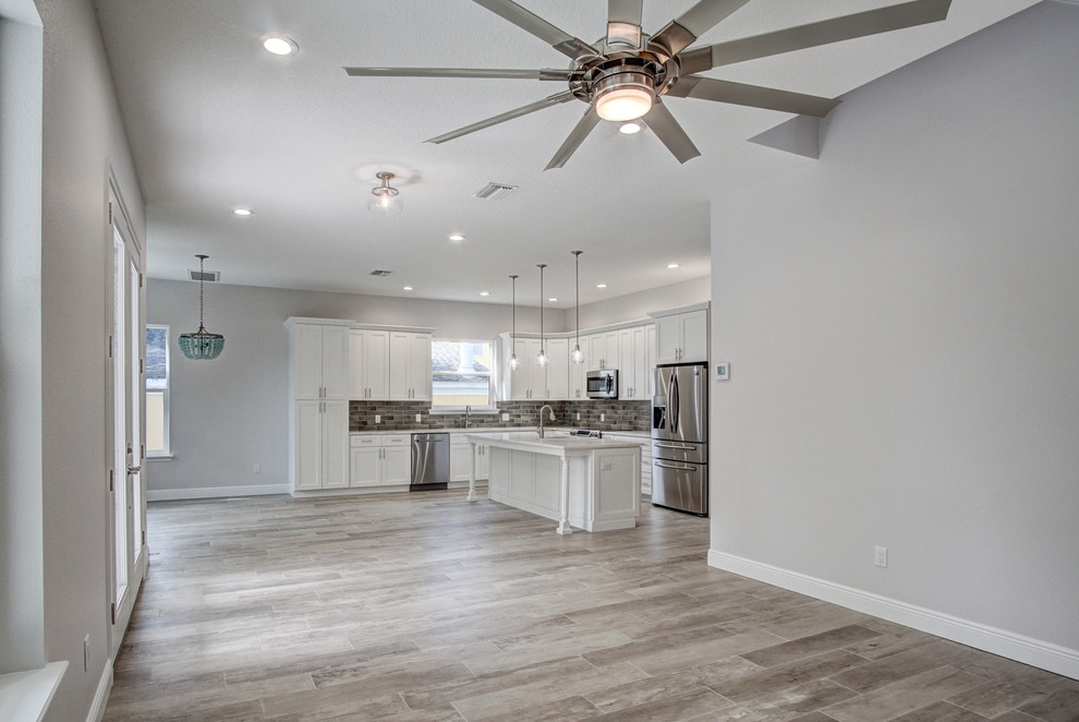 Photo of a mid-sized beach style open concept family room in Tampa with grey walls, ceramic floors, no tv and grey floor.
