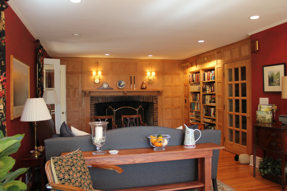 Inspiration for a mid-sized country open concept family room in Bridgeport with a library, brown walls, light hardwood floors, a standard fireplace, a brick fireplace surround, no tv and brown floor.