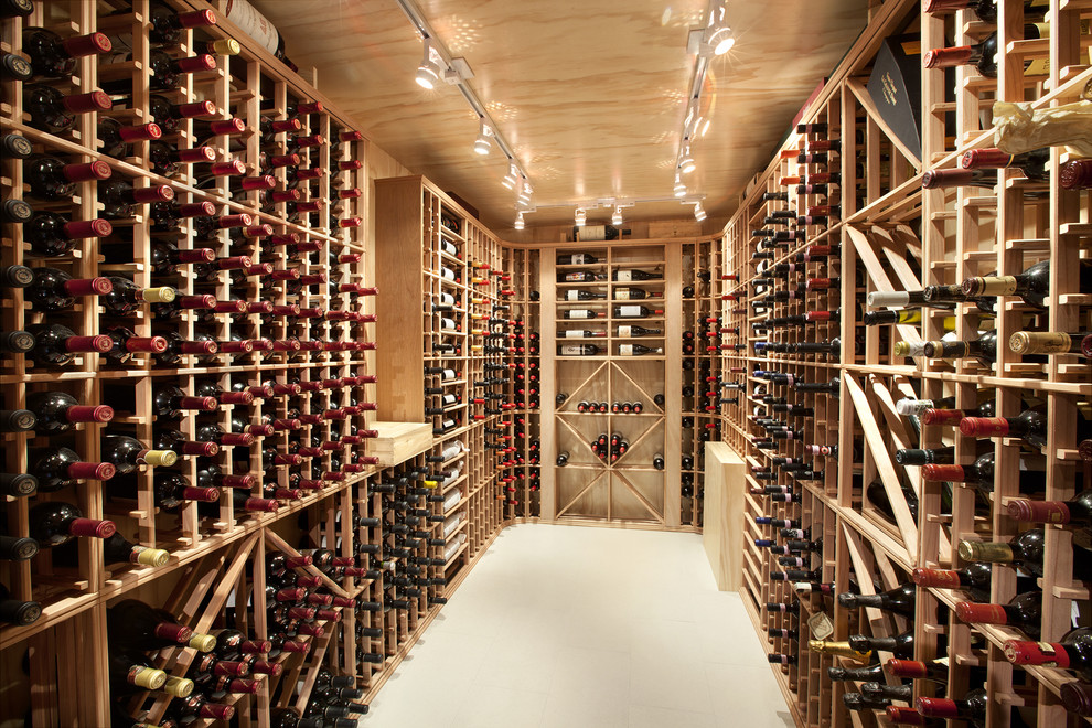 This is an example of an expansive contemporary wine cellar in Vancouver with porcelain floors and storage racks.