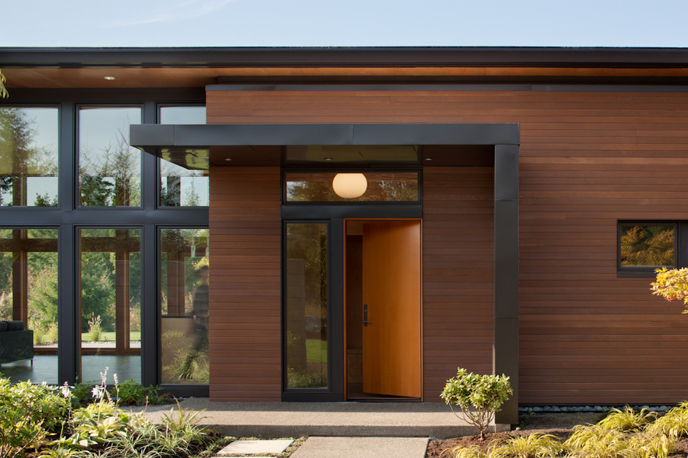 Modern entryway in Seattle with a single front door and a medium wood front door.