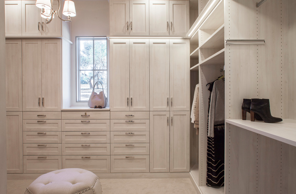 Inspiration for a transitional women's walk-in wardrobe in Austin with shaker cabinets, light wood cabinets, carpet and beige floor.