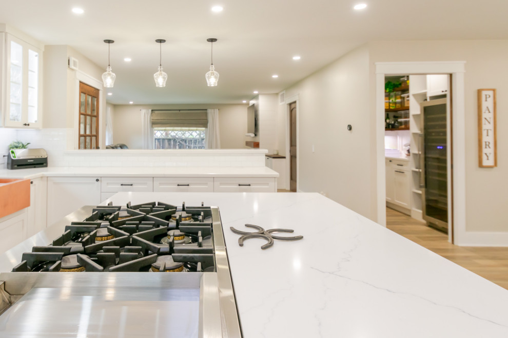 Inspiration for a huge rustic l-shaped open concept kitchen remodel in San Francisco with an undermount sink, shaker cabinets, white backsplash, ceramic backsplash, stainless steel appliances and an island