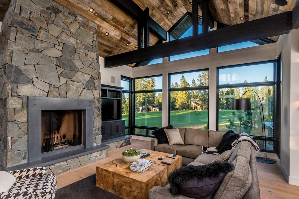 Inspiration for a country family room in Other with white walls, light hardwood floors, a standard fireplace, a metal fireplace surround and a built-in media wall.