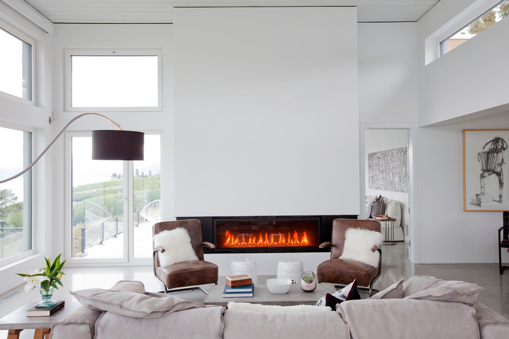 This is an example of a large contemporary open concept family room in Vancouver with white walls, concrete floors, a ribbon fireplace, a plaster fireplace surround, no tv and grey floor.