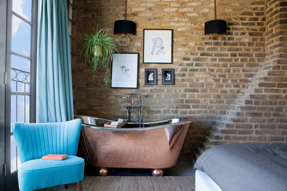 Photo of an industrial bathroom in London with a freestanding tub.