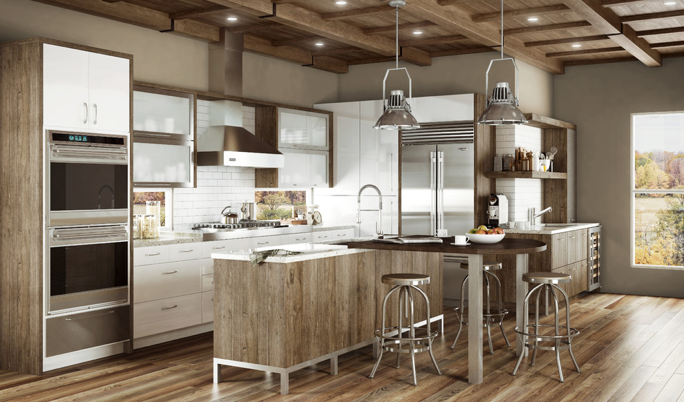 Inspiration for a contemporary kitchen in Seattle with white splashback, subway tile splashback, stainless steel appliances, flat-panel cabinets, an undermount sink, white cabinets, medium hardwood floors and with island.