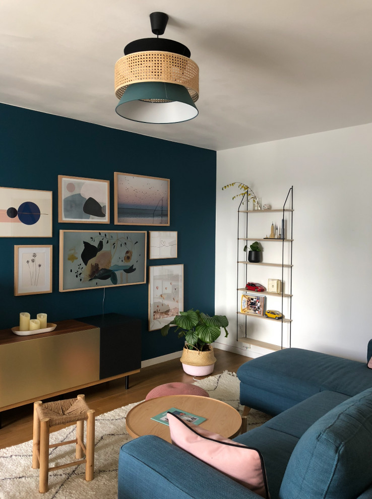 Immagine di un piccolo soggiorno nordico aperto con pareti blu, parquet chiaro, nessun camino, TV a parete e pavimento marrone