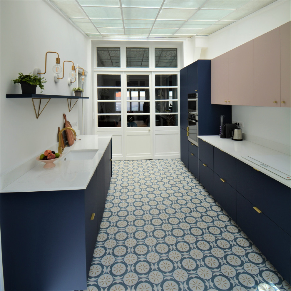 Inspiration for a large traditional galley separate kitchen in Lille with an undermount sink, flat-panel cabinets, blue cabinets, quartzite benchtops, white splashback, engineered quartz splashback, panelled appliances, cement tiles, no island, blue floor and white benchtop.