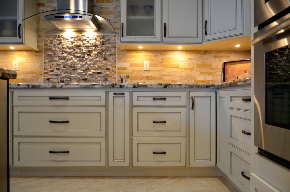 Mid-sized transitional l-shaped open concept kitchen photo in Miami with an undermount sink, flat-panel cabinets, white cabinets, granite countertops, beige backsplash, stone tile backsplash, stainless steel appliances and an island