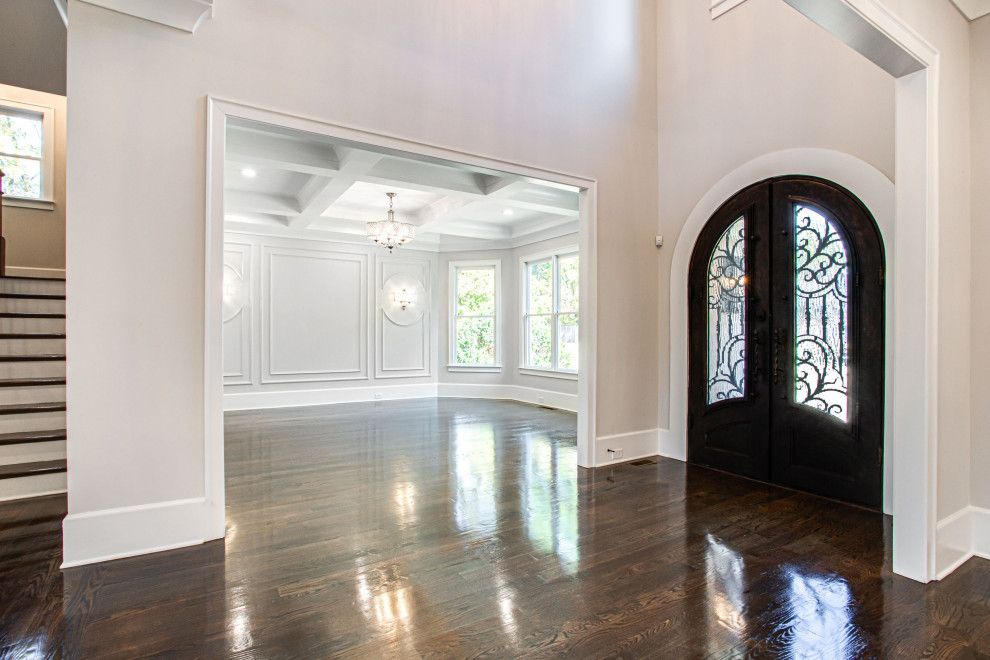 This is an example of a large transitional foyer in Atlanta with grey walls, medium hardwood floors, a double front door, a dark wood front door, brown floor and coffered.